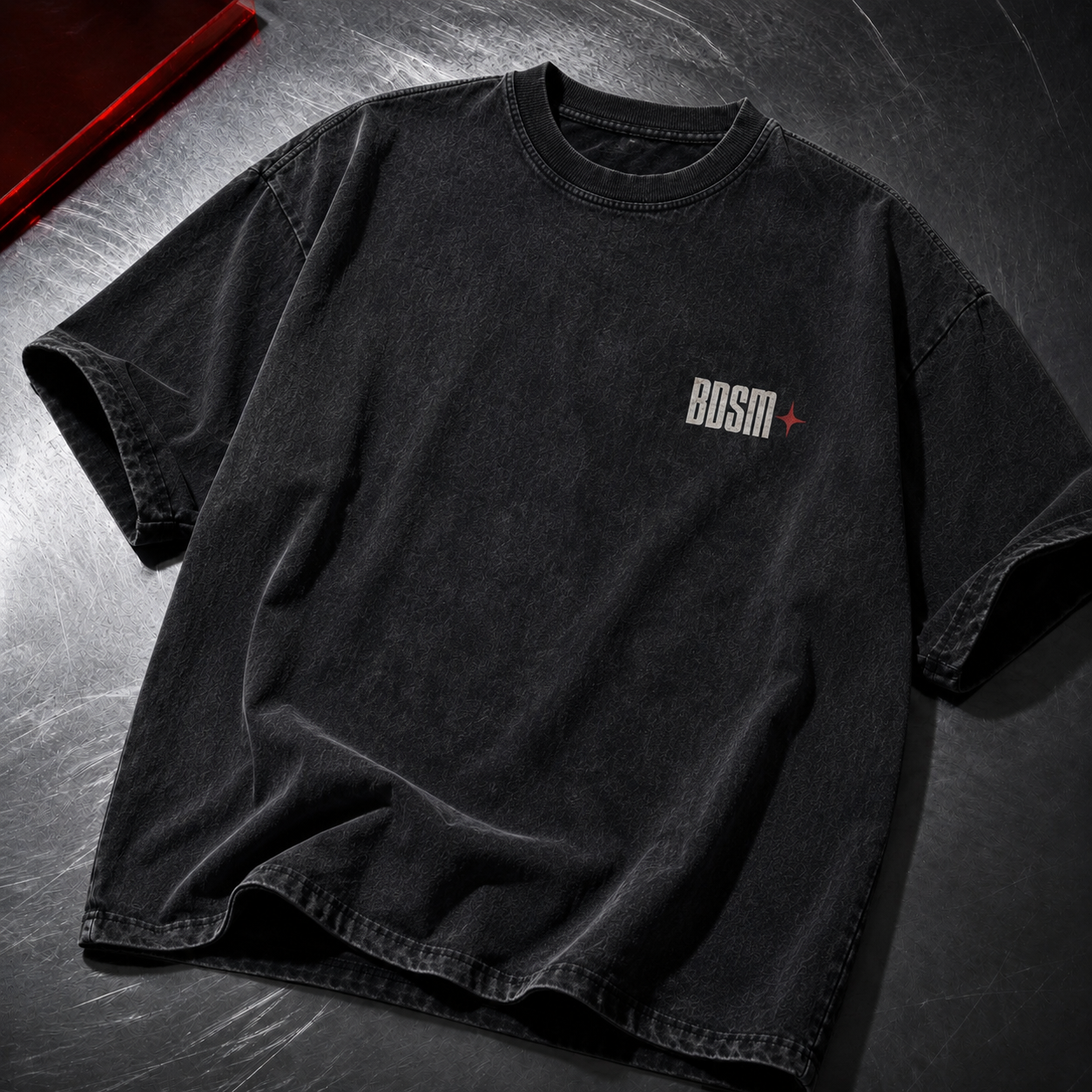 T-shirt oversize acid wash BDSM na metalowym blacie – przód z małym nadrukiem logo